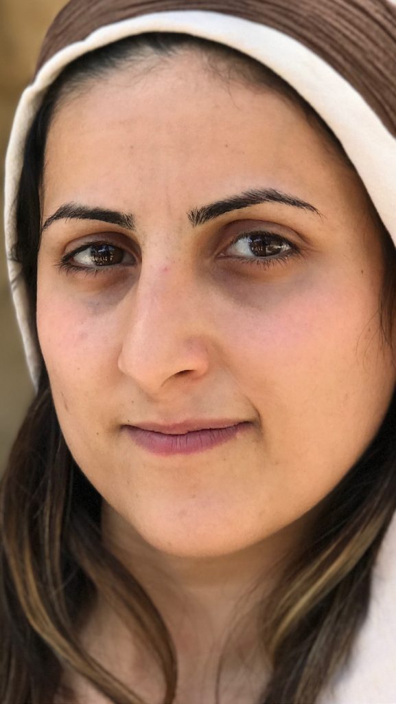A young woman in a headscarf, portraying Ruth at Nazareth Village, Israel